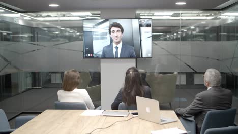 Employees-listening-to-young-leader-during-video-conference